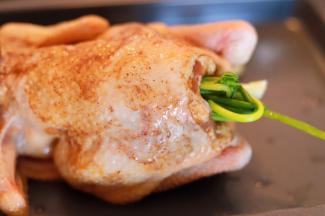 将全鸡放在烤盘上，葱和芹菜塞入鸡肚内