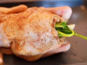 将全鸡放在烤盘上，葱和芹菜塞入鸡肚内