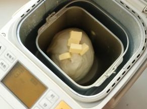 选择面团程序，揉面15分钟，再放入室温软化好的黄油。