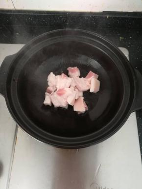 陶瓷煲内热油，放入肥一点的肉煸出油脂香气。
