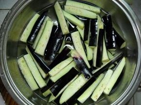 准备好紫茄子。 茄子洗净、切粗条；用冷水浸泡10分钟。
