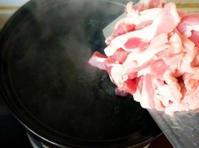 砂锅内水滚开下切好的肉皮的肉片和适量姜片