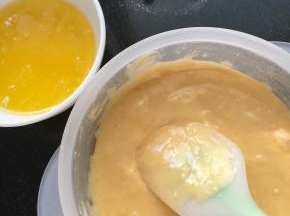 黄油隔水融化 或放微波炉里叮10秒 加一半到面糊了 搅拌均匀 以半圆弧形搅拌 或画井字型搅拌至无颗粒 再加入另一半黄油