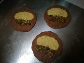 面团擀成圆片，均匀铺上曲奇糊和栗子碎