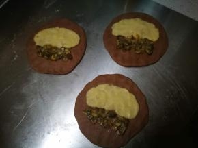 面团擀成圆片，均匀铺上曲奇糊和栗子碎