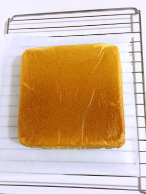 立马倒扣，彻底晾凉即可！烤架上铺一层油纸，把方形烤盘里面的戚风蛋糕倒扣过来，撕掉蛋糕上的油纸，晾凉！