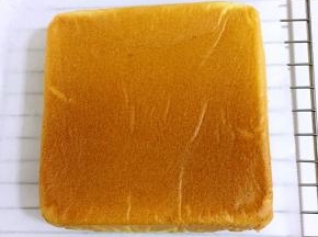 立马倒扣，彻底晾凉即可！烤架上铺一层油纸，把方形烤盘里面的戚风蛋糕倒扣过来，撕掉蛋糕上的油纸，晾凉！
