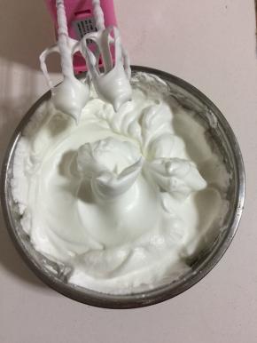 蛋白里面加入2滴白醋和白糖100克，用电动打蛋器先高速打发蛋白，感到蛋白有厚重感了改为中速打发蛋白，直到打到像图片上这样蛋白打发到有坚挺的小尖角了，再改为低速打发几下，整理一下蛋白里面的气泡。（打发蛋白的时候可以把烤箱预热着！）