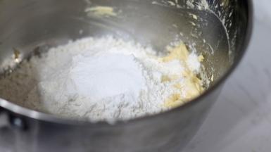 加入过筛后的低筋面粉和泡打粉。（如果不想加泡打粉，就要确保黄油打发彻底，依靠打发的黄油和全蛋液也可以膨胀）