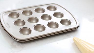 准备好模具，蛋糕糊装入裱花袋中。用的是学厨的这款棒棒糖蛋糕。防粘效果好，不需要涂抹黄油了。