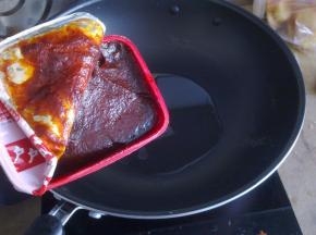 锅里倒入油，调成小火，倒入辣椒酱。