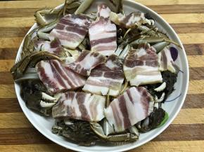 把切成片的咸肉铺在蟹上面。
