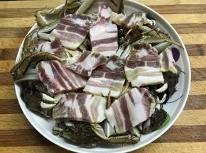 把切成片的咸肉铺在蟹上面。