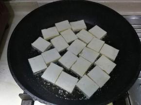 油温八成热时，加入豆腐块，大火煎2分钟至底部金黄色