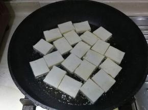 油温八成热时，加入豆腐块，大火煎2分钟至底部金黄色
