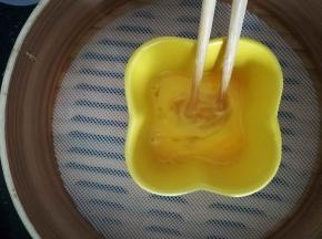 鸡蛋打入碗中，搅盘。