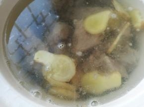 烧开水倒入电炖锅中，将出过水的猪骨捞出放入，生姜切片放入