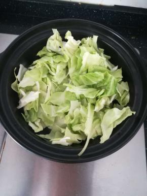 加入包菜，翻炒均匀。盖上盖子焖两至三分钟。