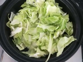 加入包菜，翻炒均匀。盖上盖子焖两至三分钟。