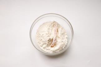 鸡胸肉腌制好，去除葱姜蒜辣椒，先取一个放在面粉碗里滚一圈