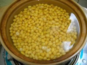 泡好的黄豆入水煮熟。