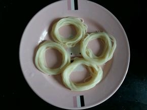 盘子底刷一层菜籽油，防止面条和鹌鹑蛋蒸熟后粘盘子。煮软的面条，摆成圆圈。