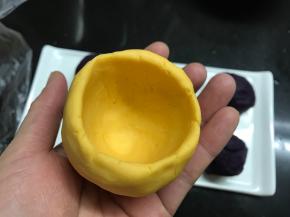 取1个南瓜面团捏成碗状。