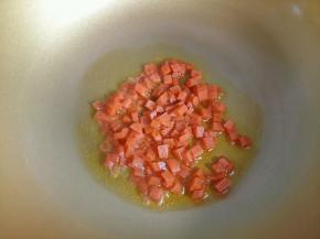 热锅凉油，倒入胡萝卜丁翻炒。