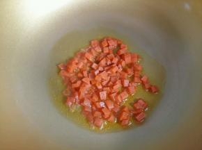 热锅凉油，倒入胡萝卜丁翻炒。