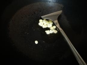 锅烧热，倒入花生油，放入切好的大蒜瓣