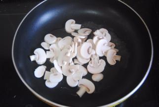 热锅，锅内倒入一勺橄榄油，倒入蘑菇片翻炒半分钟