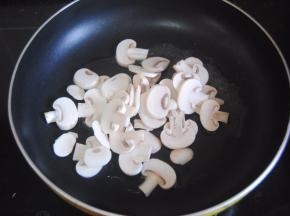 热锅，锅内倒入一勺橄榄油，倒入蘑菇片翻炒半分钟