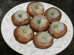 将虾仁盘在香菇伞里，放一颗豌豆做装饰。