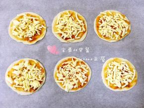 披萨酱上面撒一层马苏里拉芝士碎。