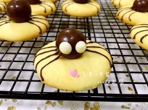 再取两颗白色巧克力豆粘在麦丽素中间做蜘蛛的眼睛。