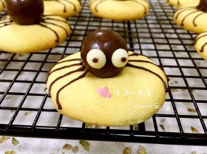 用巧克力酱在白巧克力上点出黑色眼仁，蜘蛛曲奇饼干就做好了！待饼干表面的巧克力酱晾干后再放入包装袋密封保存即可。