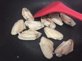 中火，热锅冷油，放入鸡中翅煎至二面变有点金黄