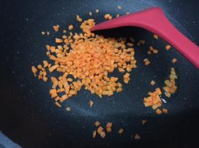 中火，热锅冷油，放入红萝卜碎进去翻炒2分钟