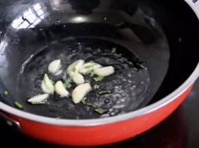 锅中放油烧热，葱花和蒜瓣爆香
