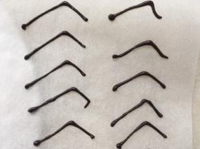 在油纸上挤出蜘蛛腿形状的线条，巧克力凉透就可以取下来啦，留一部分巧克力酱一会做蜘蛛时用