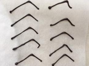 在油纸上挤出蜘蛛腿形状的线条，巧克力凉透就可以取下来啦，留一部分巧克力酱一会做蜘蛛时用