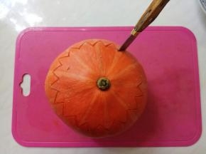 在表皮三分之一处，用小刀刻出锯齿状花纹。每一刀扎透至南瓜芯部。