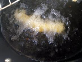 锅里油烧热，将一对重叠的面条用手在两端稍微拉长，放入油锅中