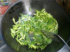 锅中倒少许油，加入蒜苔翻炒。