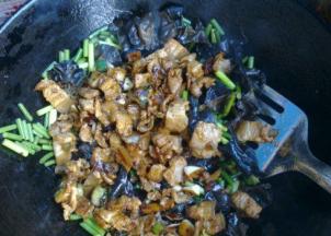 加入刚才炒好的肉再继续翻炒，倒入少许白酒去肉腥提菜香。再翻炒几十秒至蒜苔脆嫩断生即可。关火，撒少许鸡精，炒匀出锅。