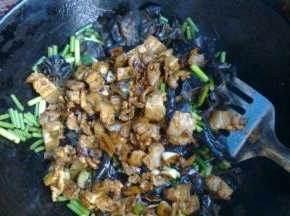 加入刚才炒好的肉再继续翻炒，倒入少许白酒去肉腥提菜香。再翻炒几十秒至蒜苔脆嫩断生即可。关火，撒少许鸡精，炒匀出锅。