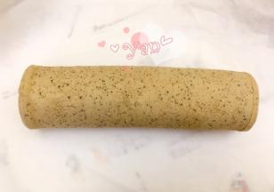 用擀面杖卷住油纸，顺势往上推。卷起来，两边跟拧糖一样拧起来。放入冰箱冷藏半小时后再切块食用。