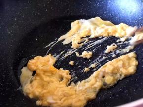 将鸡蛋在碗中加盐打散放入锅中快速炒散