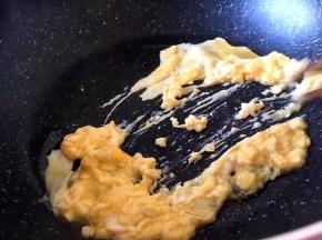 将鸡蛋在碗中加盐打散放入锅中快速炒散
