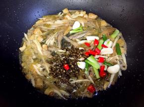 接着放入蒜，葱，小红尖椒和花椒炒香。